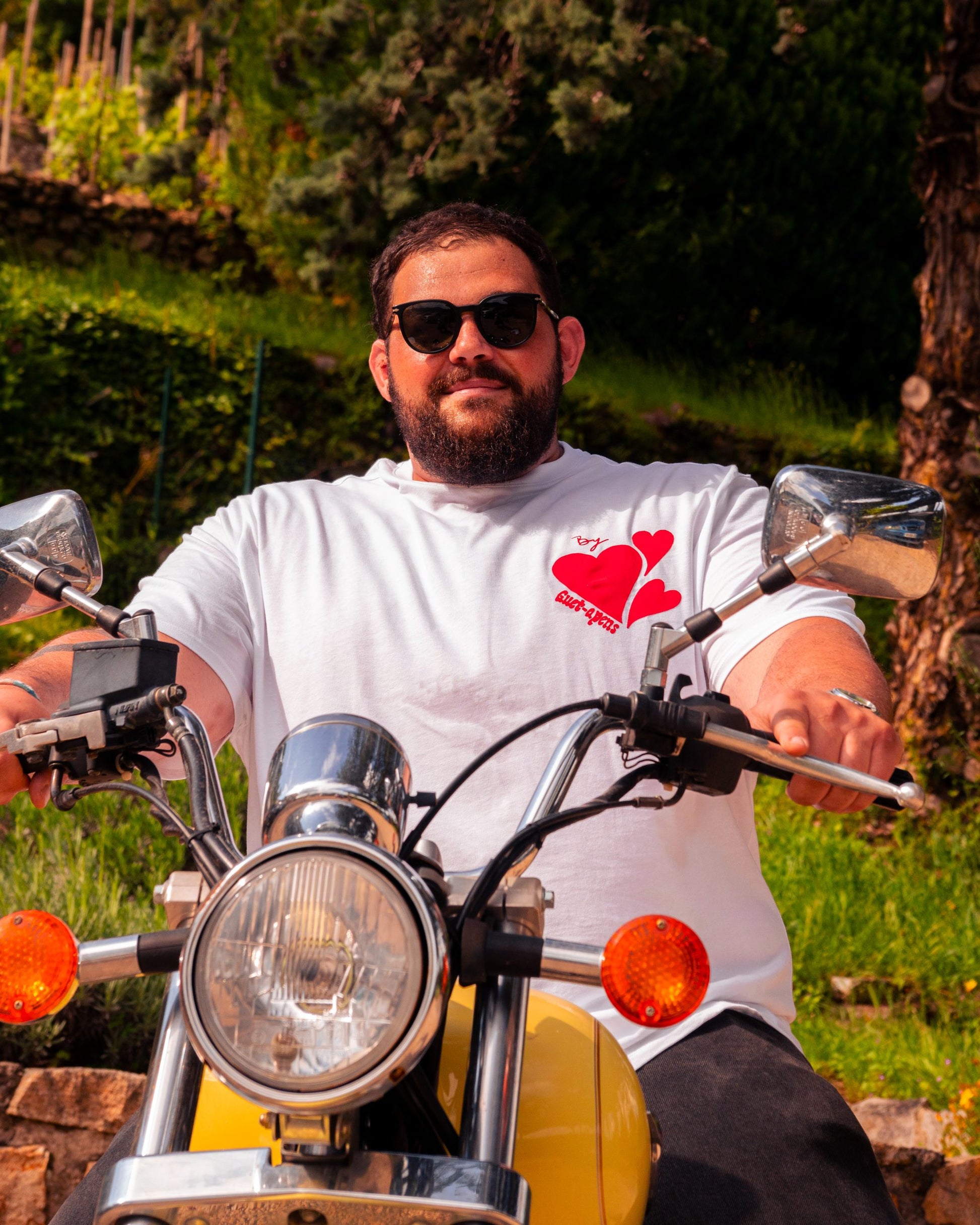 T-shirt oversize blanc avec trois coeurs rouge sur le devant et le nom de la marque Guet-apens.